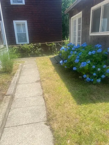 a view of brick house with a yard