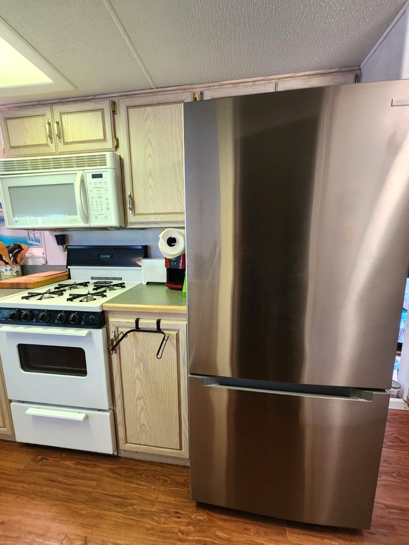 28-21 Woodhaven Sublette, IL 61367 - Photo 29 of 35 a kitchen with stainless steel appliances a refrigerator a stove and a sink