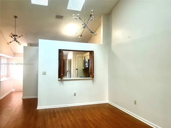 a view of a room with wooden floor and a ceiling fan