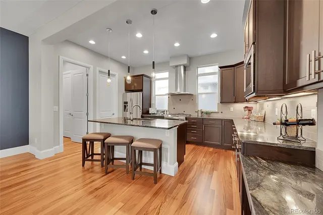 a kitchen with stainless steel appliances granite countertop wooden cabinets a sink stove and a granite counter top