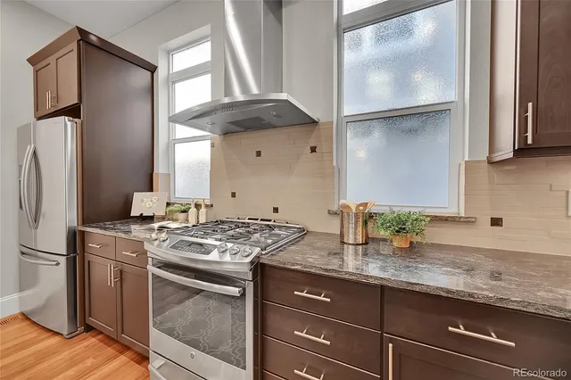 a kitchen with granite countertop a sink stainless steel appliances and cabinets