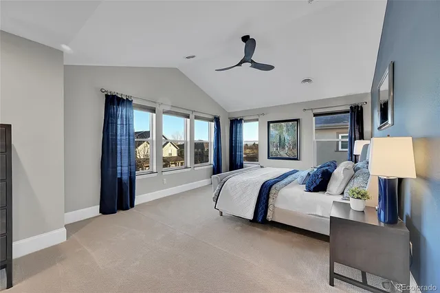 a spacious bedroom with a large bed and a chandelier