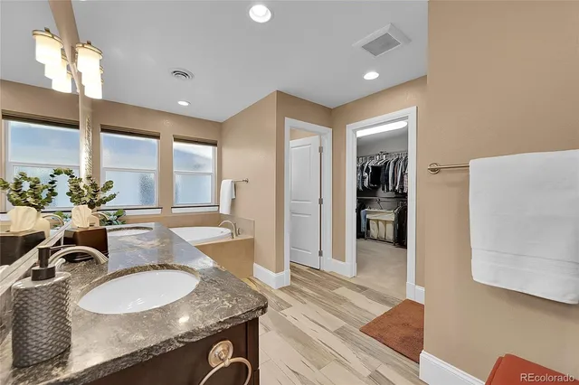 a spacious bathroom with a granite countertop sink and a mirror
