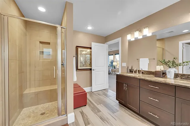 a bathroom with a sink mirror and shower