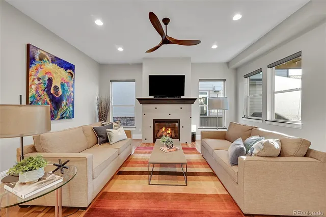 a living room with furniture a fireplace and a flat screen tv