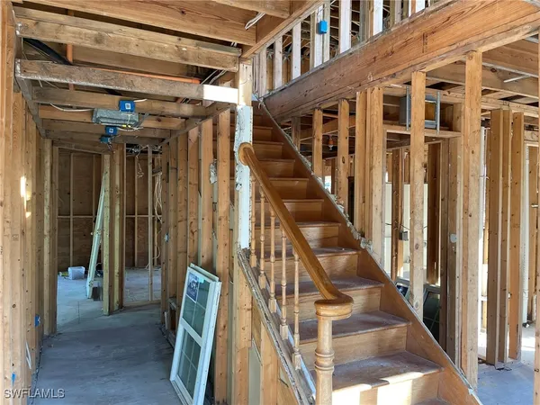 a view of staircase with lots of frames on wall and windows