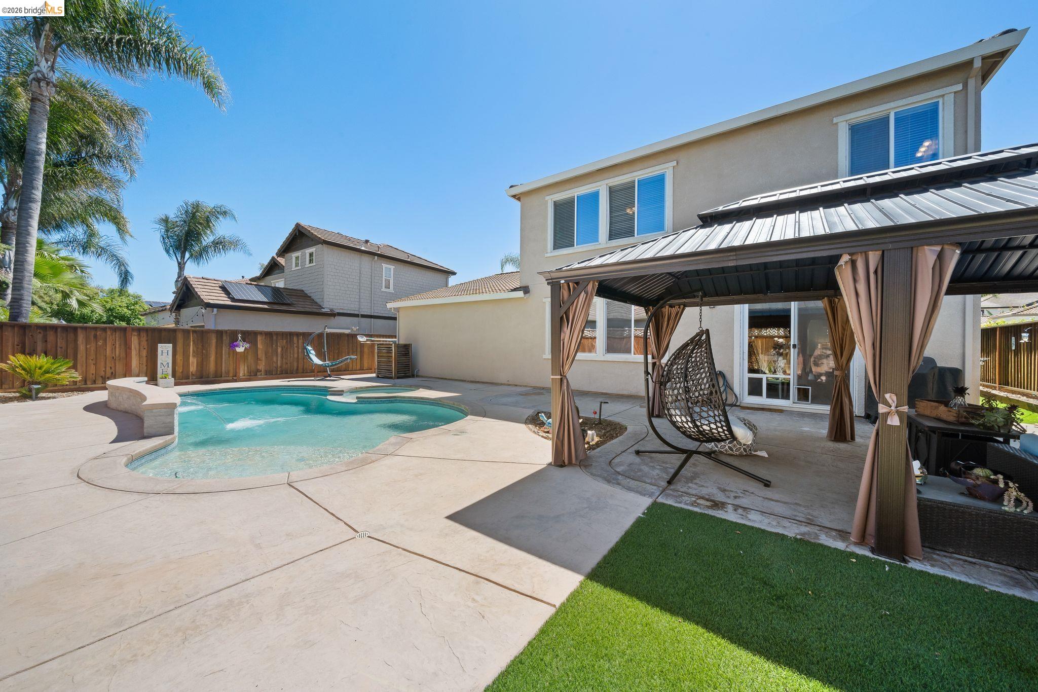 2350 Winchester Loop Discovery Bay, CA 94505 - Photo 1 of 1 Back of house featuring a patio, a gazebo, stucco siding, a fenced backyard, and a metal roof