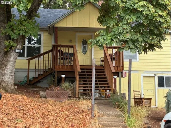 a front view of a house with glass windows and a tree