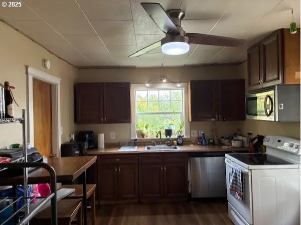 a kitchen with a stove a sink a dining table and chairs