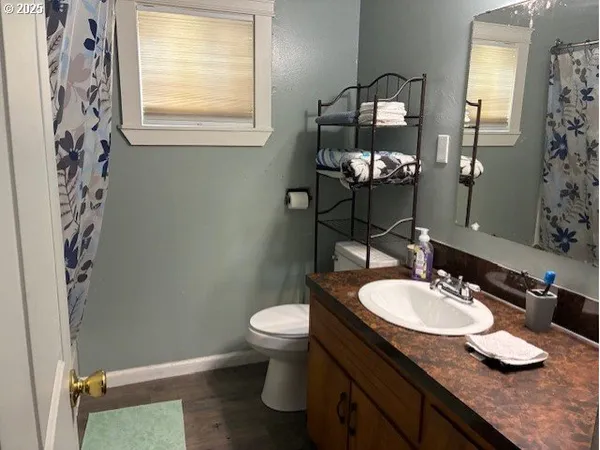 a bathroom with a granite countertop sink toilet and a mirror