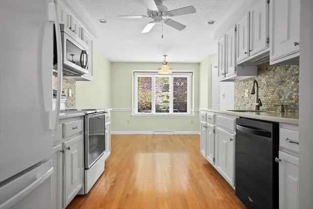 a kitchen with granite countertop white cabinets and stainless steel appliances