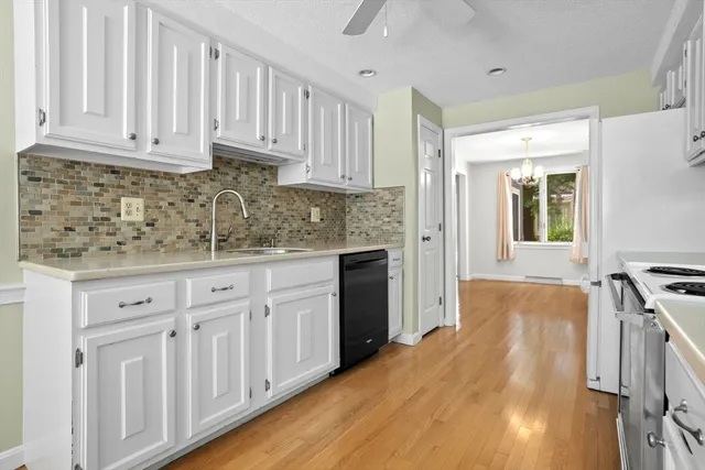 a kitchen with granite countertop white cabinets and stainless steel appliances