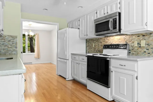 a kitchen with cabinets and wooden floor