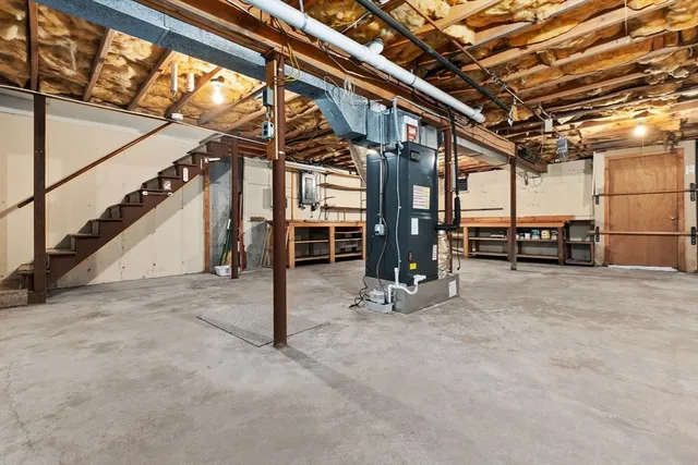 a view of an empty room with furniture and a window