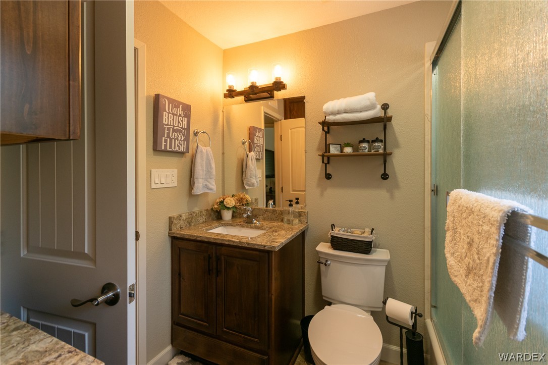 6615 Flag Mine Road Kingman, AZ 86401 - Photo 30 of 72 a bathroom with a toilet sink and mirror