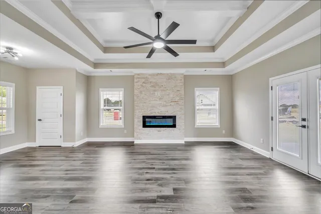 a view of an empty room with window and wooden floor