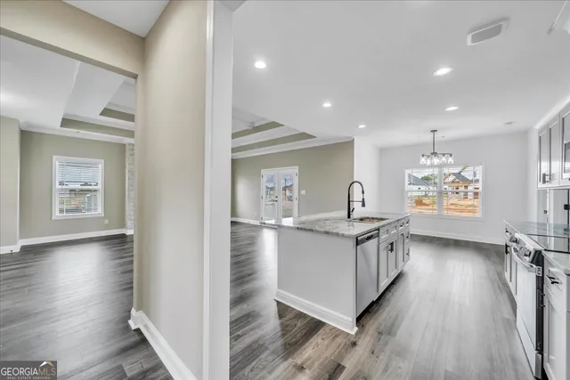a kitchen with granite countertop a stove top oven sink and wooden floor