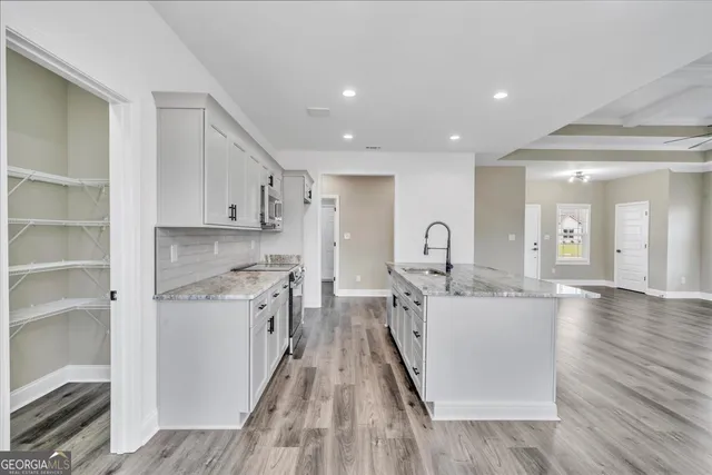 a kitchen with sink a stove and cabinets