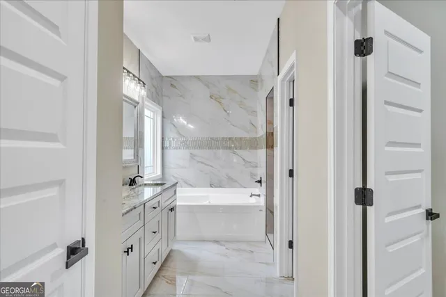 a bathroom with a tub shower and sink