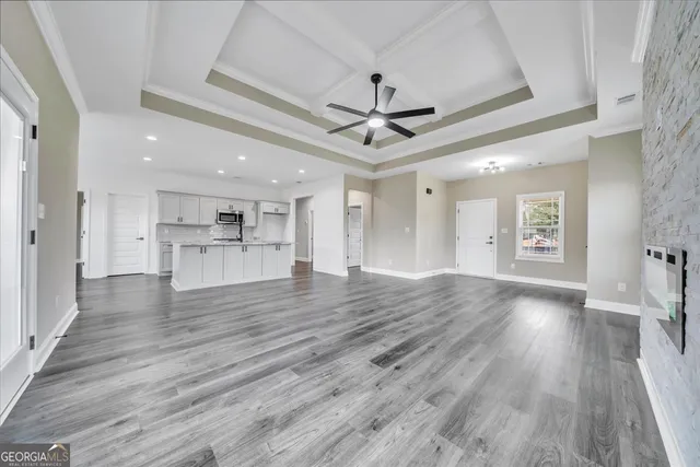 a view of a big room with wooden floor and a kitchen