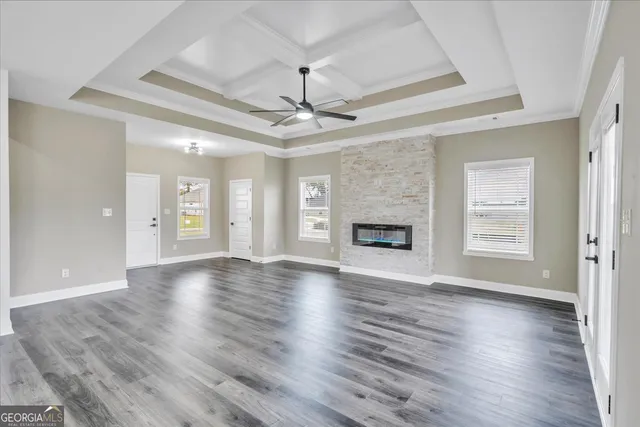 a view of an empty room with window and wooden floor