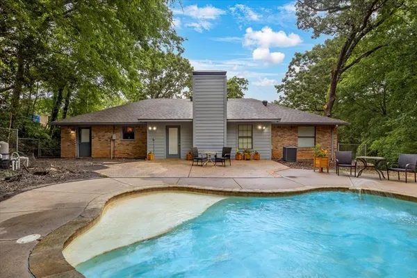 a front view of a house with swimming pool having outdoor seating