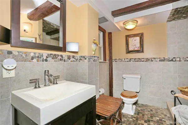a bathroom with a toilet sink and mirror