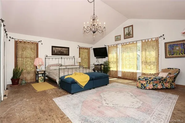 a living room with furniture a chandelier and a flat screen tv
