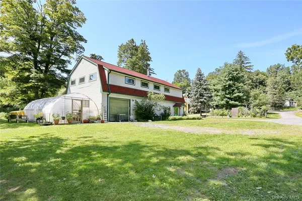 a view of a house with wooden deck and furniture
