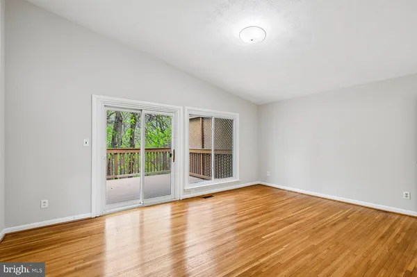 a view of empty room with wooden floor