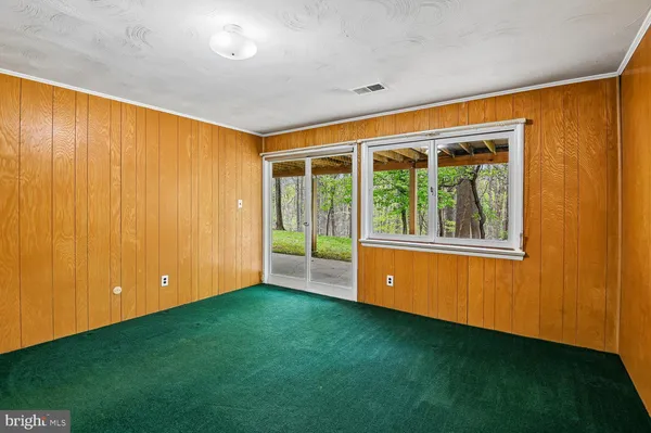a view of an empty room with window and stairs