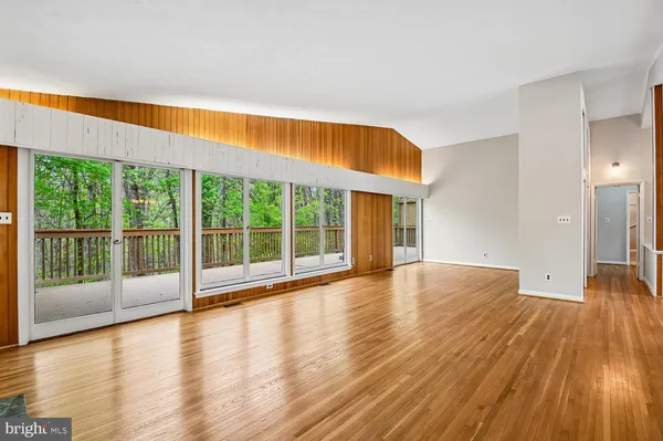a view of empty room with wooden floor and fireplace