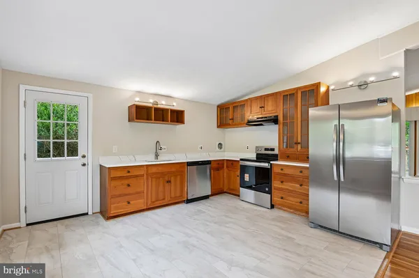 a view of an empty room with a window and a kitchen area