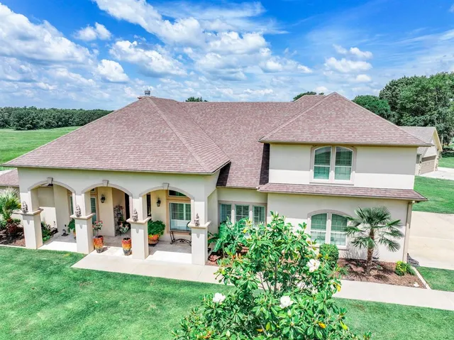 a front view of a house with a garden and plants