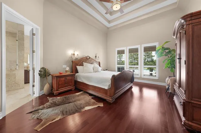 a bedroom with a bed table closet and a large window