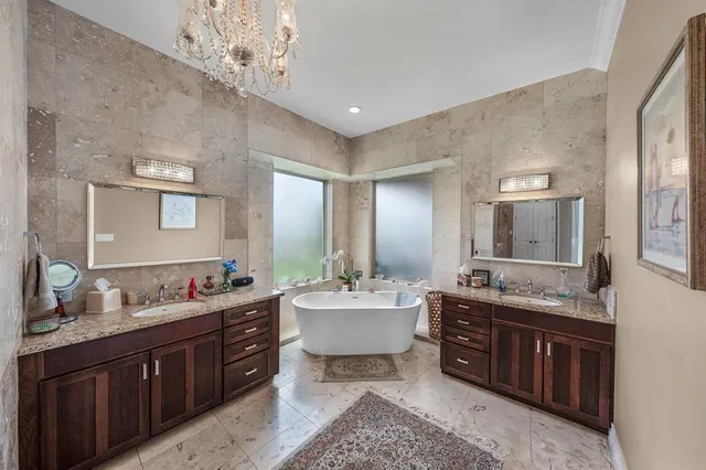 a spacious bathroom with a double vanity sink double mirror and bathtub