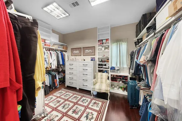 a view of walk in closet with clothes and shoes