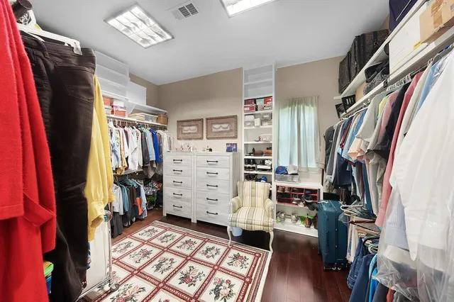 a view of walk in closet with clothes and shoes