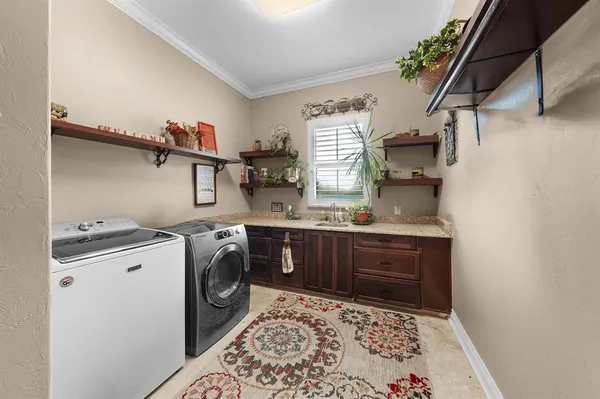 a utility room with sink dryer and washer