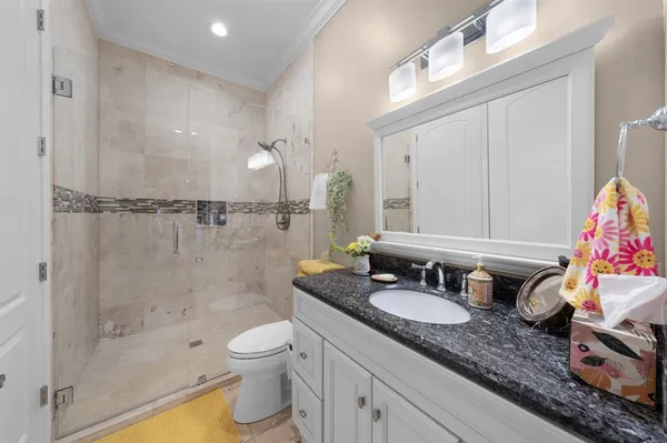 a bathroom with a granite countertop sink a toilet and shower
