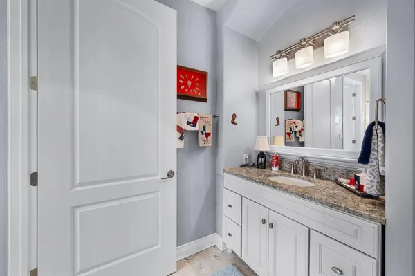 a bathroom with a sink vanity and a mirror