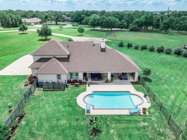 an aerial view of a house with swimming pool and garden