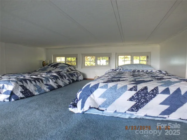a bed sitting in a bedroom next to a window