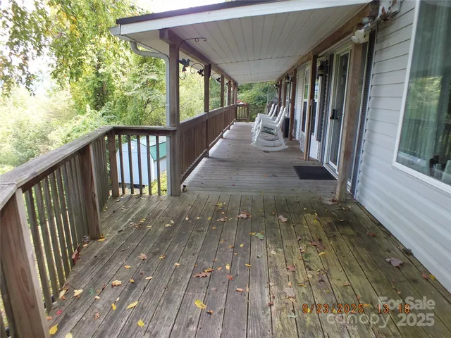 a view of a porch with wooden floor and floor to ceiling window