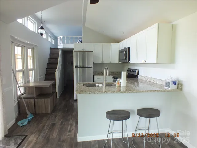 a kitchen with stainless steel appliances granite countertop a stove top oven a refrigerator a sink and dishwasher