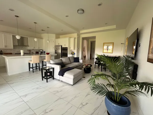 a living room with furniture and a dining table with kitchen view