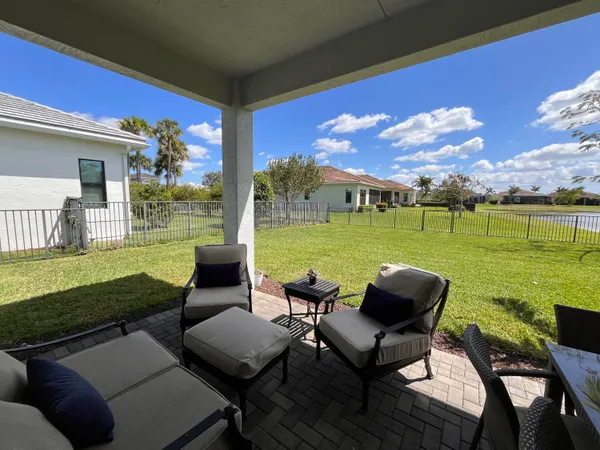 a view of a patio with lawn chairs floor to ceiling window fire pit and yard
