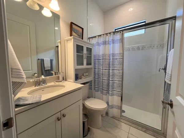 a bathroom with a sink a toilet and shower