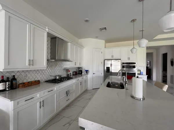 a kitchen with stainless steel appliances granite countertop a stove sink and cabinets