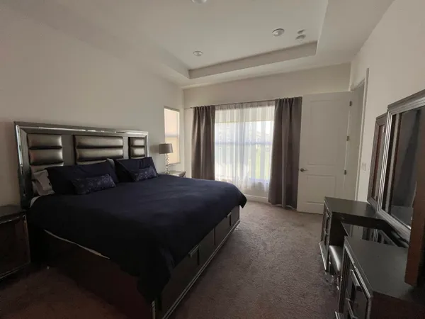 a bedroom with a bed tv and a window